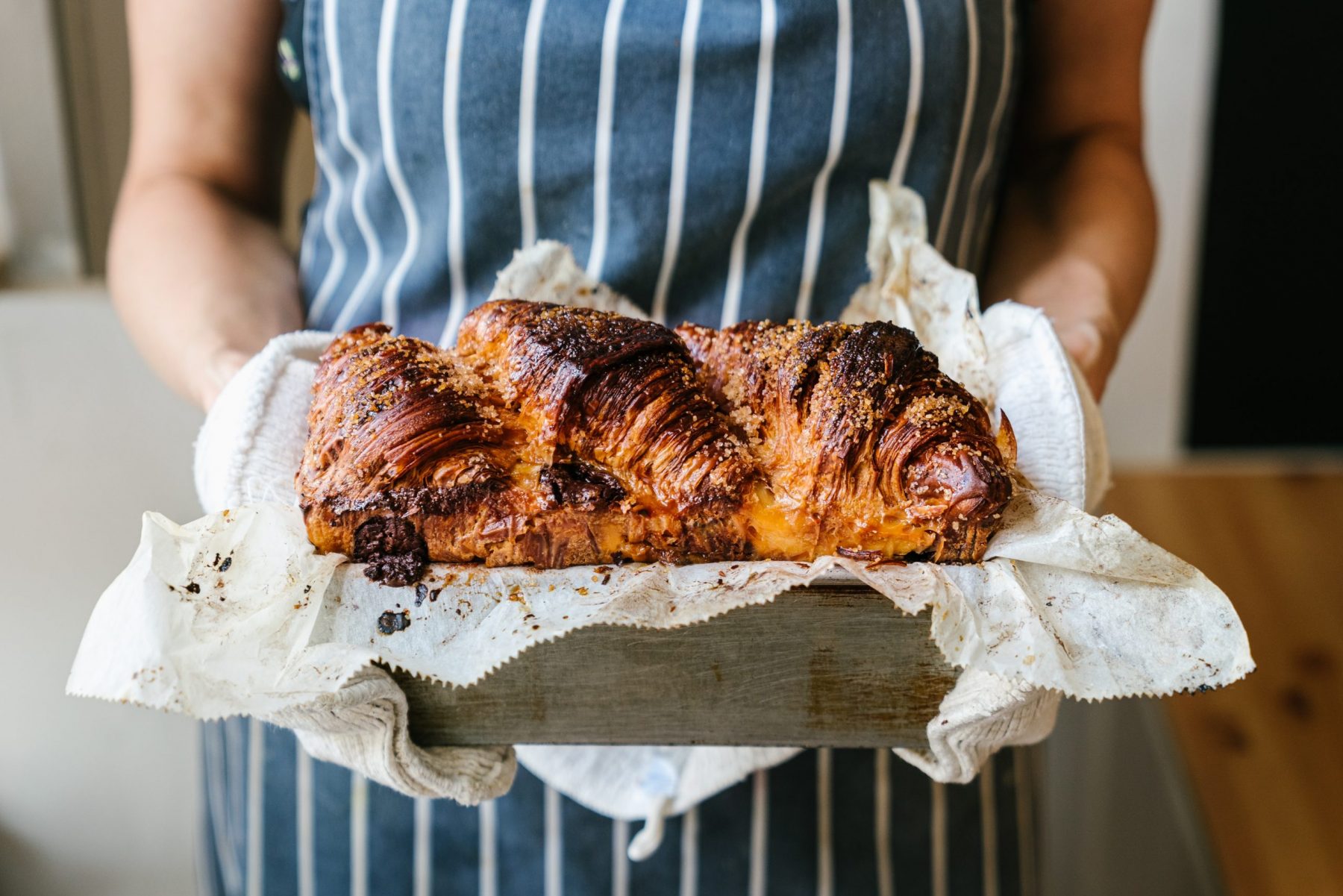a woman holding baked croissants from Twelve Triangles Edinburgh coffee shop, best coffee edinburgh, coffee shops in edinburgh