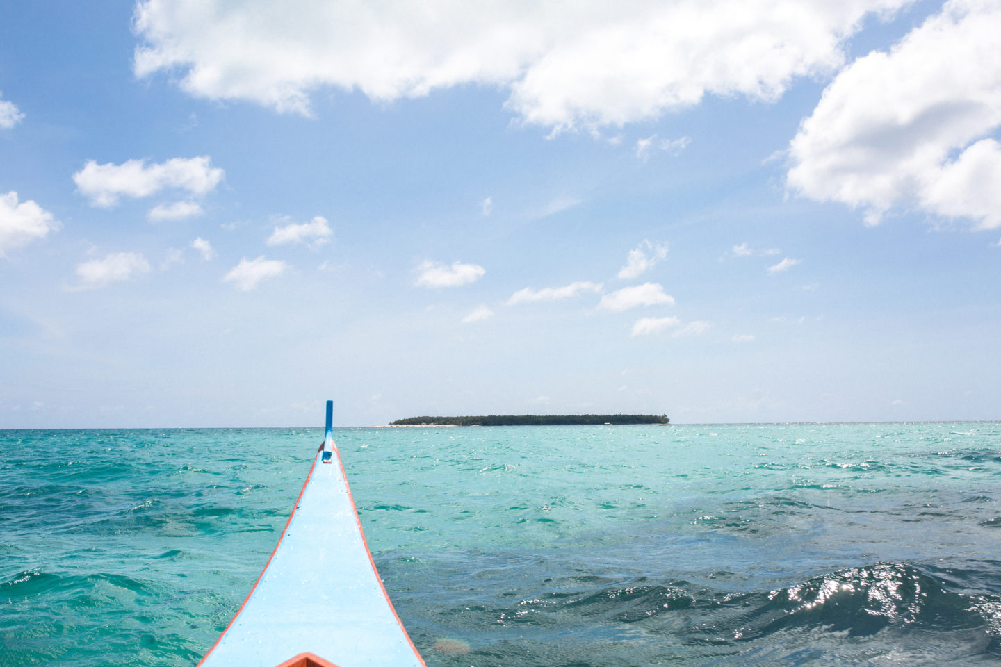 boat view of a deserted island in Siargao, the Philippines over crystal clear water itinerary 2 weeks