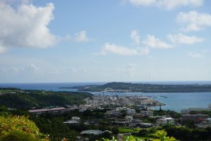 

A bridge connects two islands in Okinawa surrounded by turquoise blue seas. A small town hugs the beach