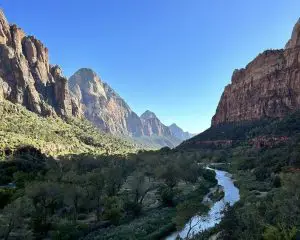 The Virgin River flows through the tall canyon walls of Zion Canyon, framing a stunning down tunnel view of an easy hikes in Zion