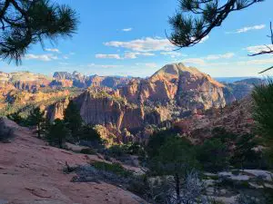 Desert peaks covered in green foliage expand over a wide canyon in Zion National Park's backcountry where one of the best easy hikes in Zion is tucked away