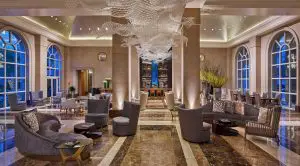 An beige-toned luxury hotel lobby with warm ambient light and opulent decor at the Hotel Crescent Court, located in one of the best areas to stay in Dallas without a car.