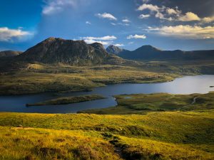 Golden evening light over the Scottish Highlands and lochs, showcasing natural beauty that makes Scotland on a budget trips so rewarding.