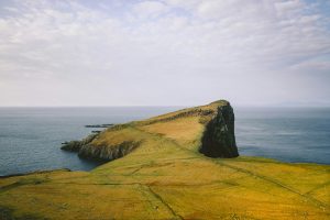 Panoramic view of Neist Point on the Isle of Skye, Scotland, with dramatic sea cliffs and grassy headlands — a stunning stop for travelers visiting Scotland on a budget.
