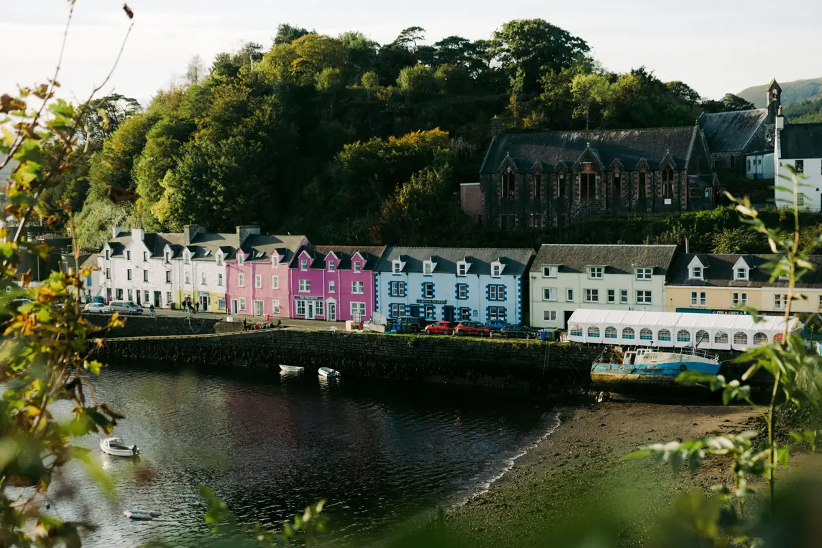 The iconic waterfront view of the colorful houses lining the harbor in Portree, the capital of the Isle of Skye, Scotland.