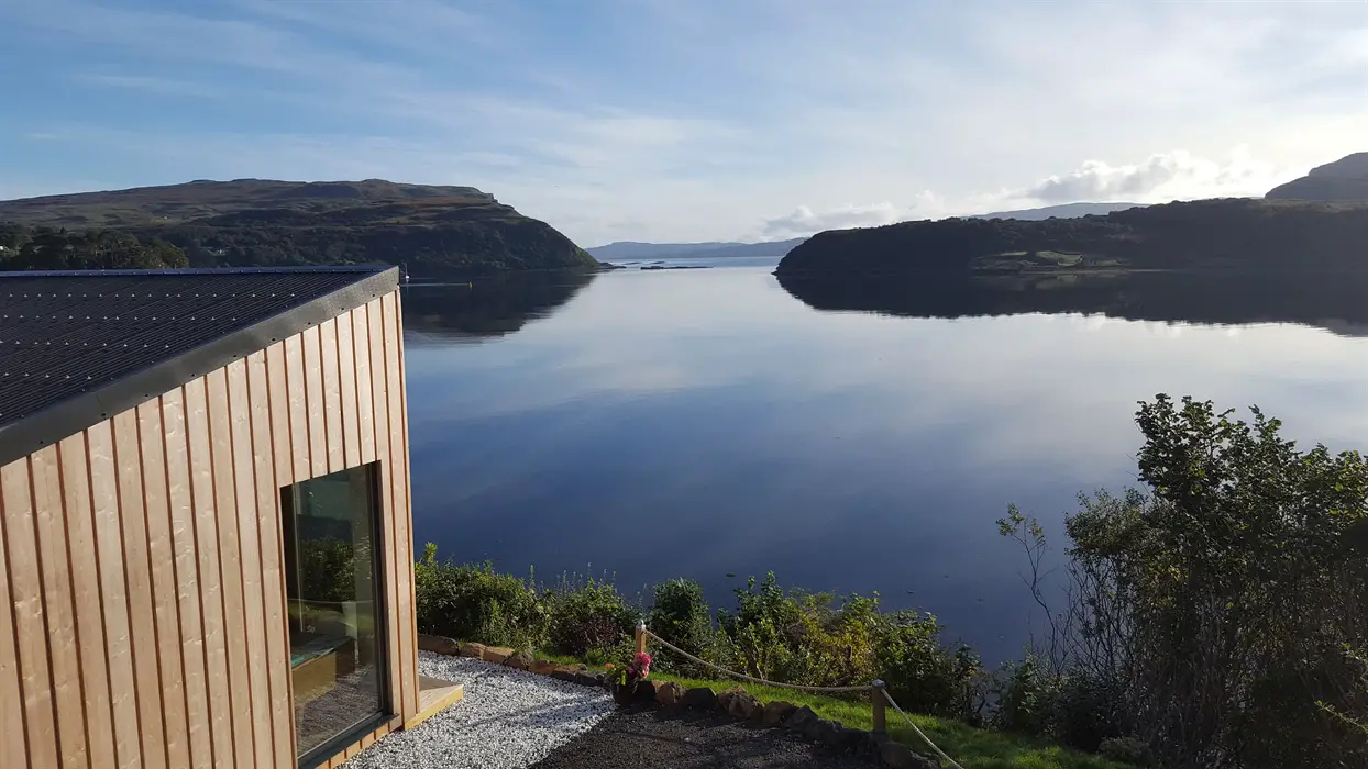 Modern wooden luxury pod accommodation, Air an Oir near Portree, featuring stunning views of the loch and hills—a top choice for unique stays on the Isle of Skye.